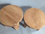 two small wooden stools sitting next to each other on a table