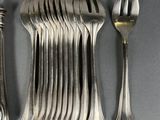 a lot of forks and spoons that are on the table
