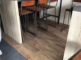 tables and chairs in a room with a bar and a refrigerator
