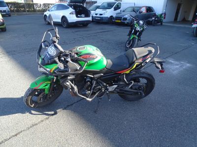 une moto verte et noire garée sur un parking
