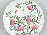 une assiette blanche décorée d'une peinture représentant des pêches
