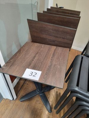 a small table with a number on it next to a stack of chairs
