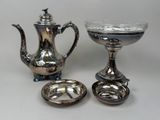 une théière en argent et un bol en argent posés sur une table