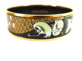 a black and gold bracelet with a bird design on it