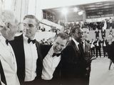 photographie en noir et blanc d'un groupe d'hommes en smoking lors d'un événement officiel