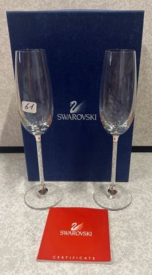 deux verres à vin vides posés sur une table, à côté d'une boîte bleue