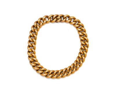 gros plan d'un bracelet en chaîne en or sur fond blanc