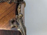 an antique wooden box with a metal handle on a blue stand