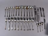 a lot of spoons and forks laid out on the table