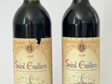 deux bouteilles de vin rouge posées l'une à côté de l'autre sur une surface blanche