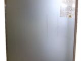 a silver refrigerator that is on wheels in a room