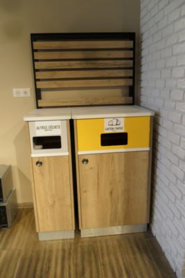 two trash bins in the corner of a room