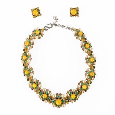 un gros plan d'un ensemble composé d'un collier et de boucles d'oreilles sur fond blanc