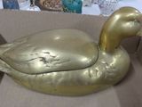 a gold duck sitting in a cardboard box on a table