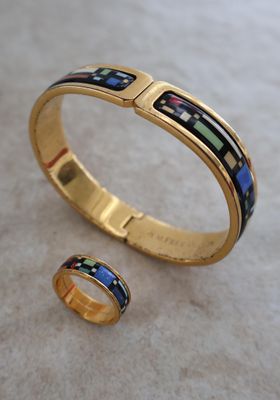 un gros plan sur un bracelet en or et une bague posés sur une table