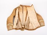 an image of a beige jacket with gold trims on a white surface