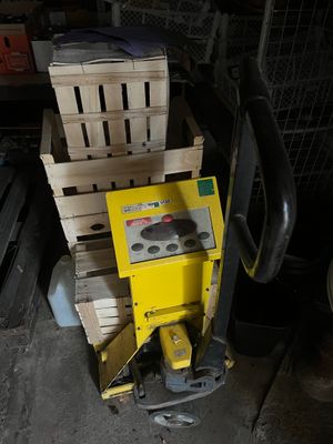 a yellow machine that is sitting next to a pile of boxes