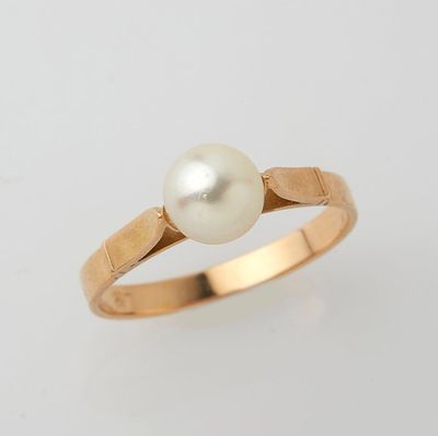 a gold ring with a pearl in the center