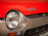 a close up of a red car with a yellow tag on it
