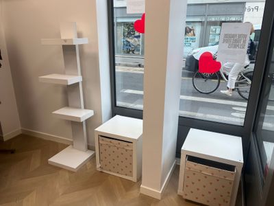 a room with a window, shelves, and a bike in the background