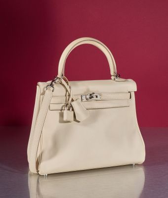 the small white purse is sitting on a table