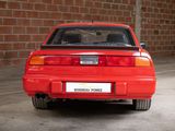 a red car parked in a garage with a brick wall in the background