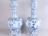 une paire de vases bleus et blancs posés sur une table blanche