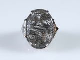 a close up of a silver ring with a black stone in it