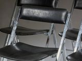 several black leather chairs are lined up in a row on the floor