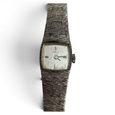 une image d'un gros plan d'une montre-bracelet sur une surface blanche