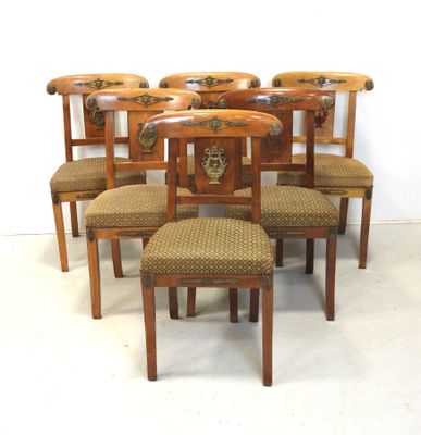 six chaises sont disposées en cercle sur une surface blanche