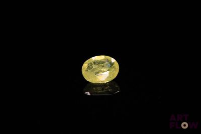 a yellow sapphire stone on a black surface