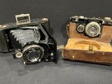 two old cameras sitting next to each other on a table