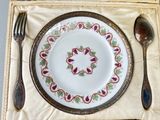 a place setting with a plate, spoon, and spoon rest