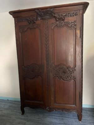 a large wooden armoire in the corner of a room