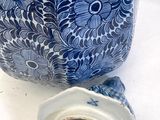 a blue and white vase sitting on a white table