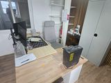 a desk with a computer on it in a small room
