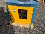 two yellow and blue generators sitting on top of a pile of gravel
