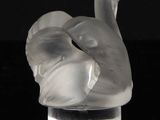 a glass sculpture of a swan on a black surface