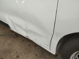 a white car that has been badly repaired and is sitting in a garage