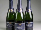 three bottles of champagne are lined up on a table