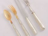 three forks and a knife are sitting next to each other on a white surface