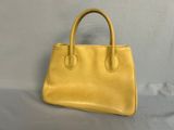 a yellow handbag sitting on top of a white table