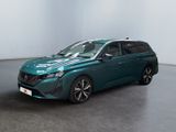 Une voiture verte est garée dans une pièce aux murs blancs.