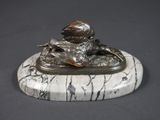statue d'un garçon assis sur un socle de marbre, tenant un oiseau dans la main