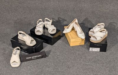 Plusieurs paires de chaussures blanches sont exposées dans une vitrine