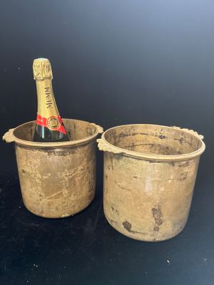 deux seaux contenant chacun une bouteille de champagne, posés sur une table