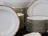 many white and gold plates and bowls on a table