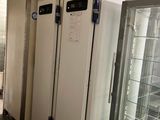 several refrigerators are lined up in a row in a room
