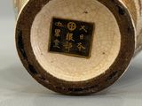 an image of a vase with a gold and white decoration on it